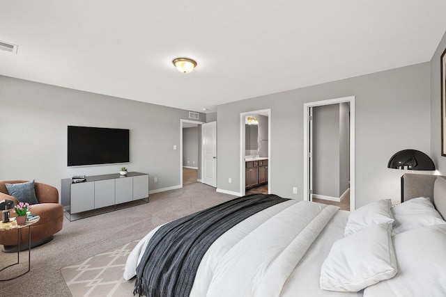 bedroom with light carpet, visible vents, baseboards, and connected bathroom