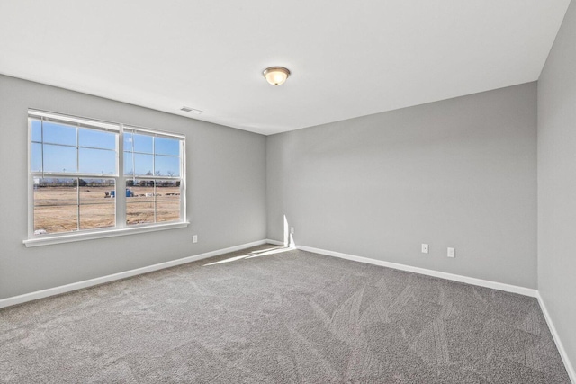 carpeted empty room featuring visible vents and baseboards