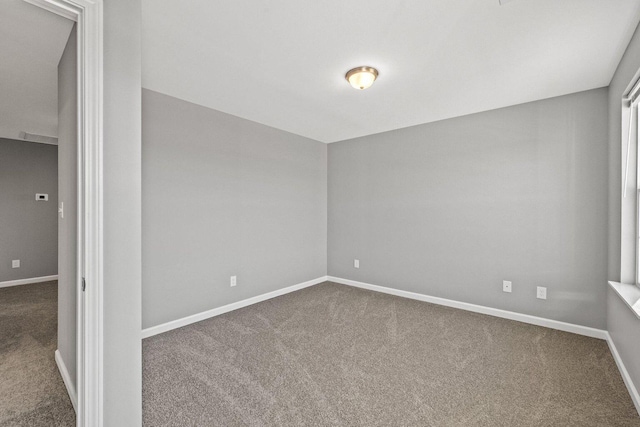 carpeted spare room with baseboards