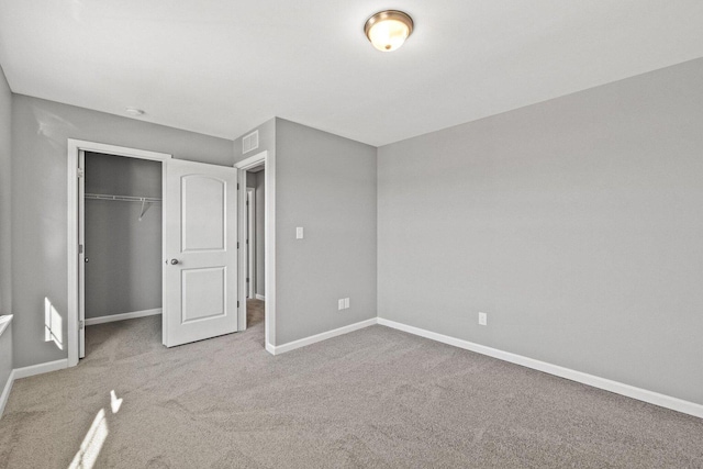 unfurnished bedroom featuring carpet, a closet, visible vents, and baseboards