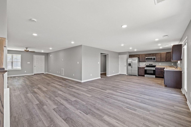 unfurnished living room featuring light wood finished floors, baseboards, a ceiling fan, and recessed lighting