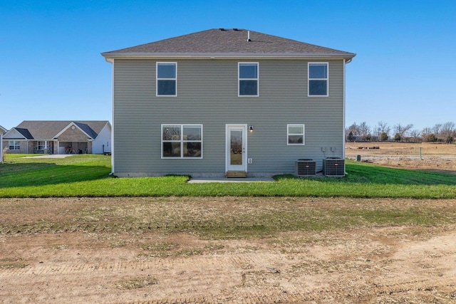 rear view of house featuring a yard and central AC unit