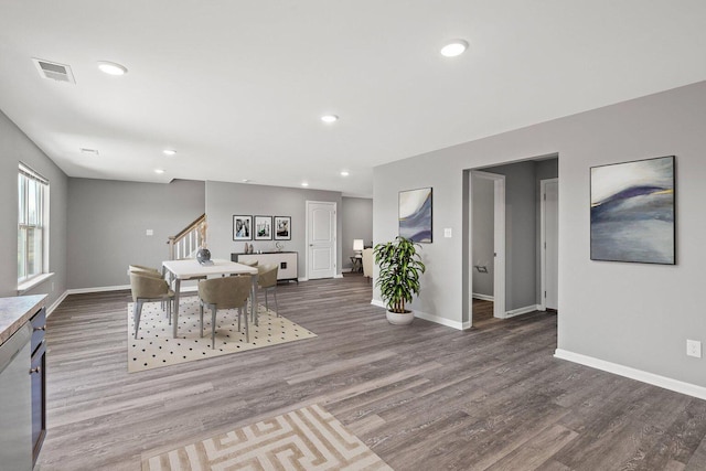 dining room featuring visible vents, stairway, baseboards, and wood finished floors