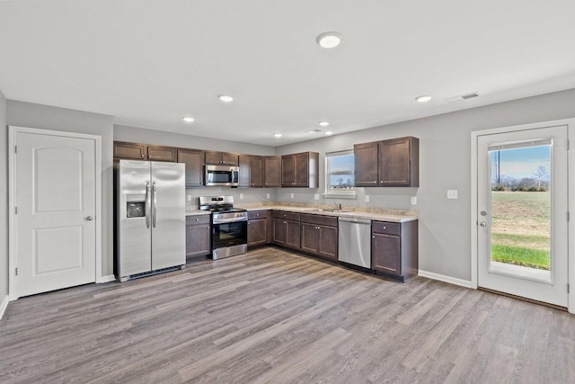 kitchen featuring visible vents, light wood-style flooring, appliances with stainless steel finishes, light countertops, and a healthy amount of sunlight