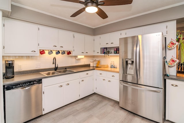 kitchen featuring tasteful backsplash, crown molding, light wood-style flooring, appliances with stainless steel finishes, and a sink