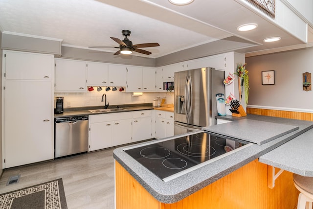 kitchen featuring visible vents, crown molding, appliances with stainless steel finishes, a ceiling fan, and a sink