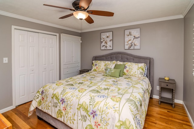 bedroom featuring ornamental molding, wood finished floors, a closet, and baseboards