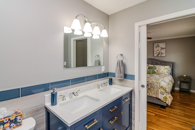 ensuite bathroom featuring double vanity, wood finished floors, ensuite bathroom, and a sink