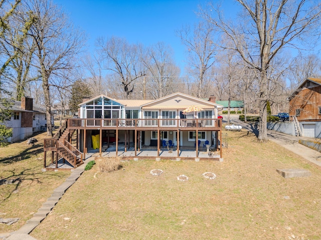 back of property with a patio, a yard, stairway, a sunroom, and a wooden deck