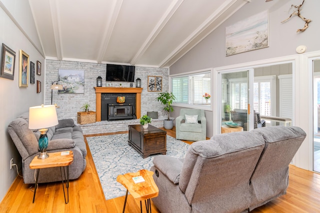 living room featuring brick wall, a brick fireplace, vaulted ceiling with beams, and wood finished floors