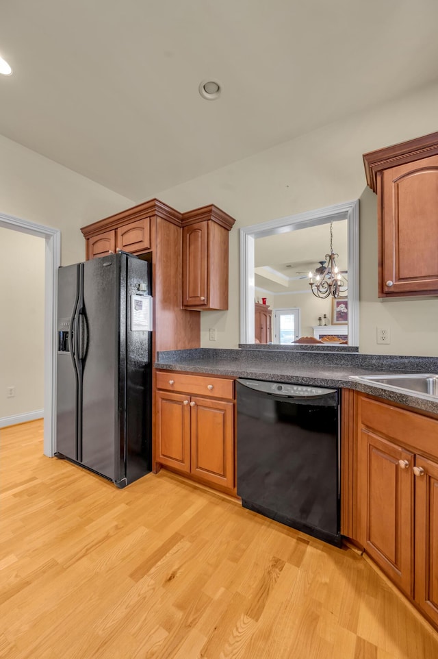 kitchen featuring brown cabinets, dark countertops, recessed lighting, light wood-style floors, and black appliances