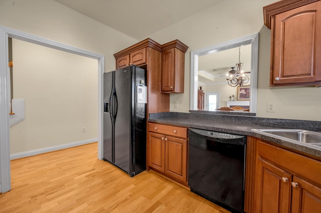 kitchen with dark countertops, black appliances, light wood-style flooring, and brown cabinets