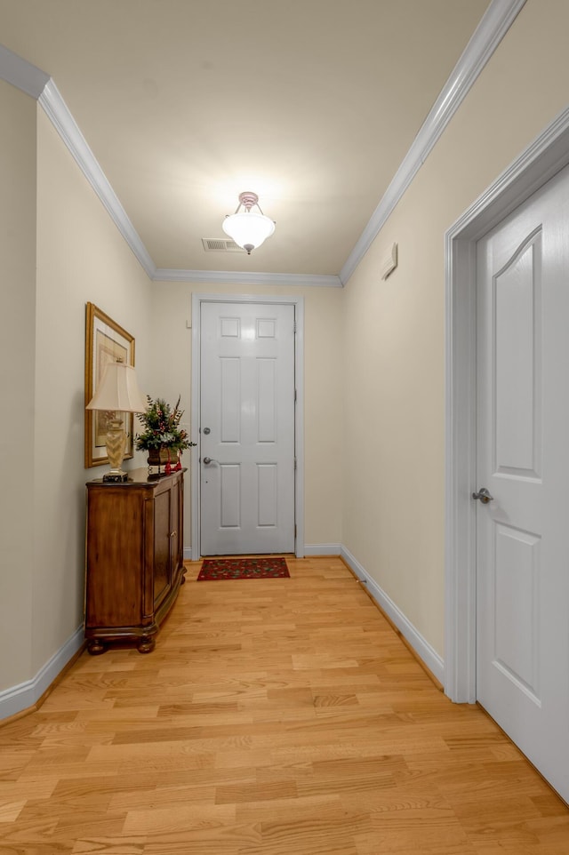 doorway with light wood-style floors, crown molding, and baseboards