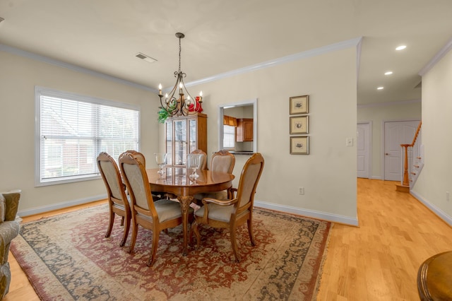 dining space featuring light wood finished floors, baseboards, visible vents, and ornamental molding
