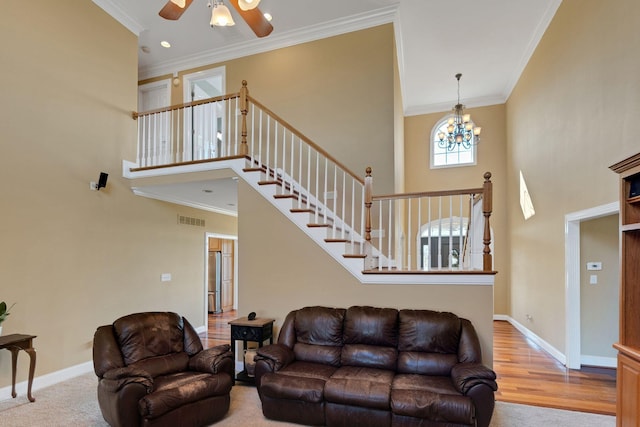 living area featuring visible vents, crown molding, and a high ceiling