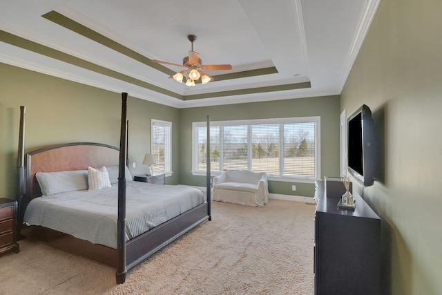 carpeted bedroom featuring baseboards, a tray ceiling, a ceiling fan, and ornamental molding