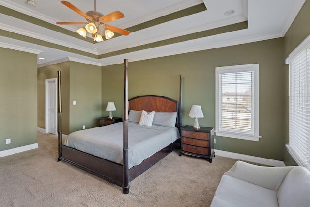 carpeted bedroom featuring a ceiling fan, a raised ceiling, crown molding, and baseboards