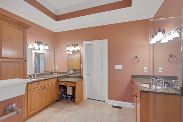 bathroom featuring baseboards, ornamental molding, two vanities, and a sink