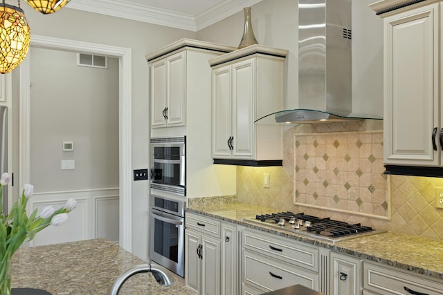 kitchen with visible vents, stainless steel appliances, crown molding, wall chimney range hood, and light stone countertops