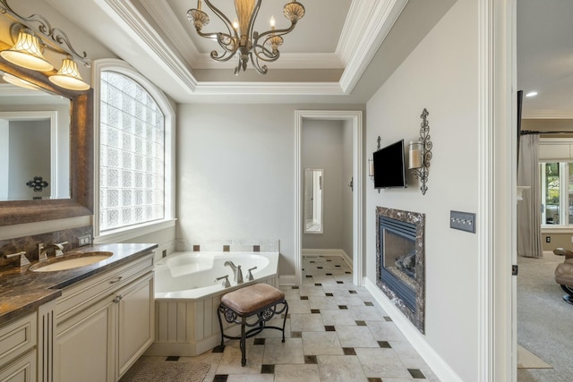 bathroom with vanity, a garden tub, a high end fireplace, crown molding, and a raised ceiling