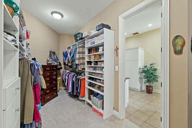 spacious closet with tile patterned floors, visible vents, and carpet