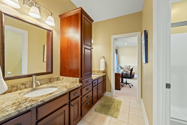 full bathroom with double vanity, baseboards, tile patterned floors, and a sink