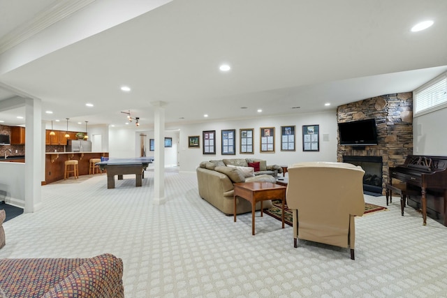 playroom with recessed lighting, light carpet, a stone fireplace, and ornamental molding