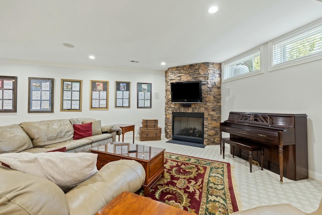 living area featuring a stone fireplace, recessed lighting, visible vents, and ornamental molding