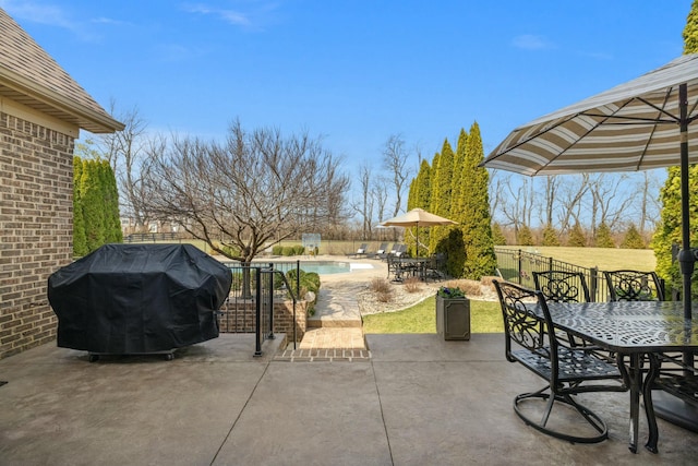 view of patio featuring outdoor dining space, a fenced in pool, and grilling area