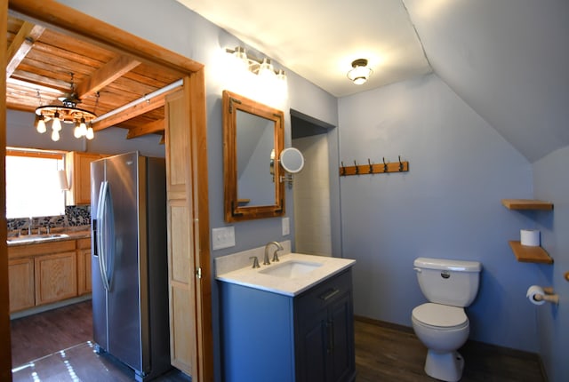 bathroom featuring vaulted ceiling, two vanities, a sink, and wood finished floors