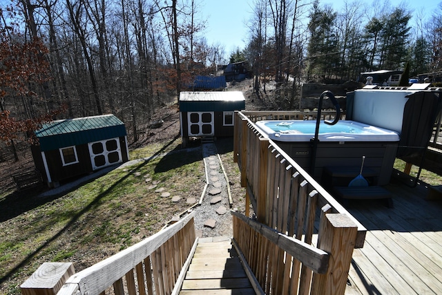 wooden deck with a storage unit, an outdoor structure, and a hot tub