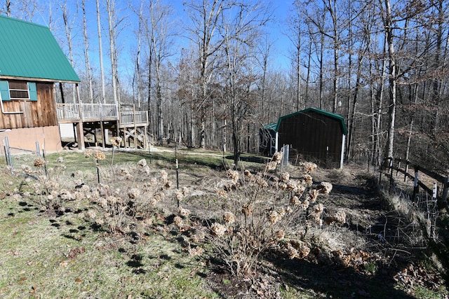 view of yard featuring a wooden deck and a detached carport