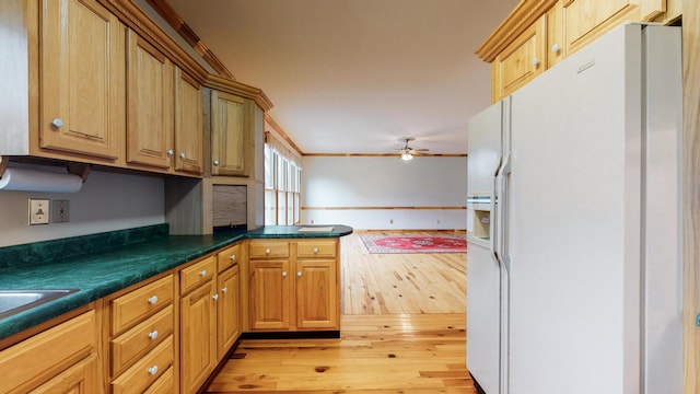 kitchen featuring light wood-style flooring, a peninsula, white refrigerator with ice dispenser, a ceiling fan, and dark countertops