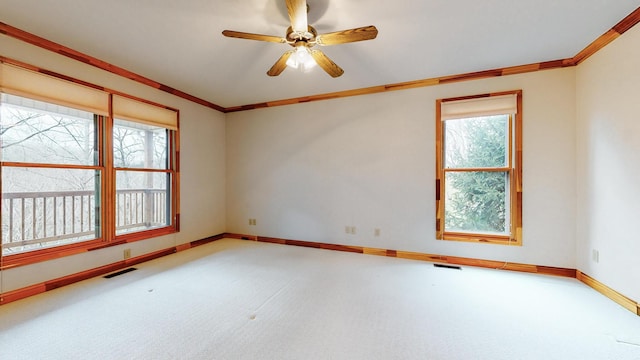 unfurnished room with ornamental molding, carpet flooring, visible vents, and baseboards