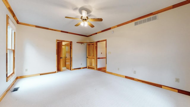 unfurnished room featuring ornamental molding, visible vents, and carpet flooring