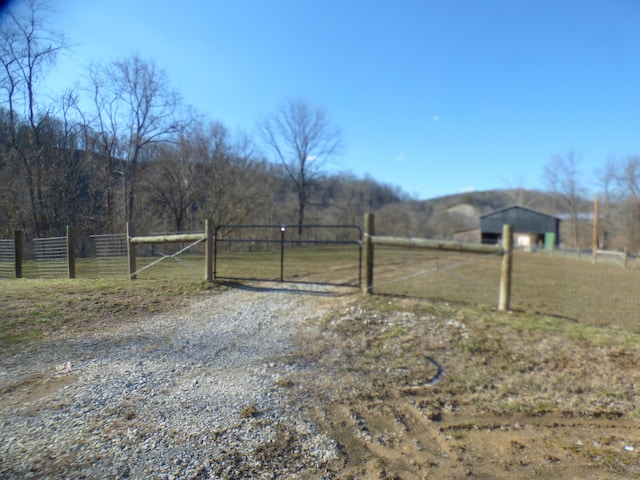 view of yard featuring a gate, fence, and a rural view