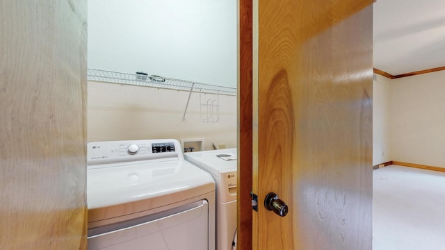 washroom featuring laundry area, baseboards, crown molding, and washing machine and clothes dryer