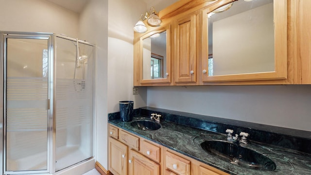 full bathroom with double vanity, a shower stall, and a sink