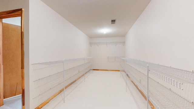 walk in closet featuring visible vents and carpet flooring