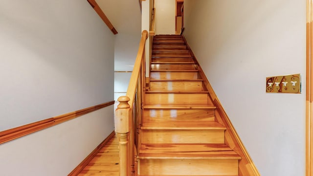 stairway with baseboards and wood finished floors