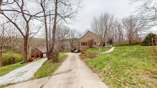 view of front of home featuring driveway, brick siding, and a front lawn