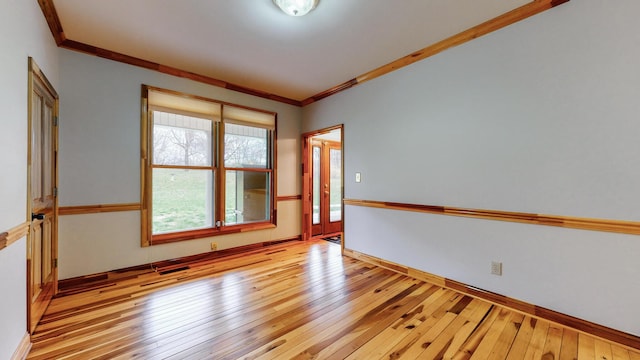 unfurnished room with crown molding, baseboards, and hardwood / wood-style flooring