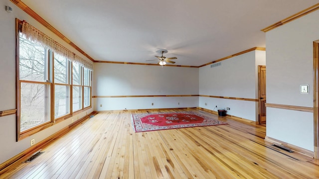 unfurnished room with baseboards, visible vents, a ceiling fan, hardwood / wood-style flooring, and crown molding