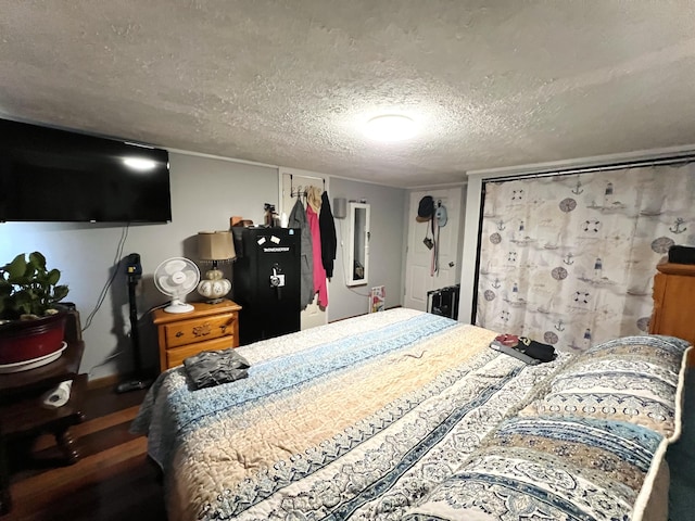 bedroom featuring a textured ceiling and wood finished floors