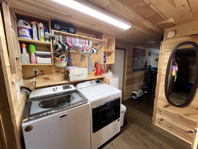 laundry area featuring dark wood finished floors, washing machine and dryer, wood ceiling, wooden walls, and laundry area