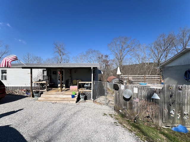 exterior space featuring a gate, fence, and metal roof