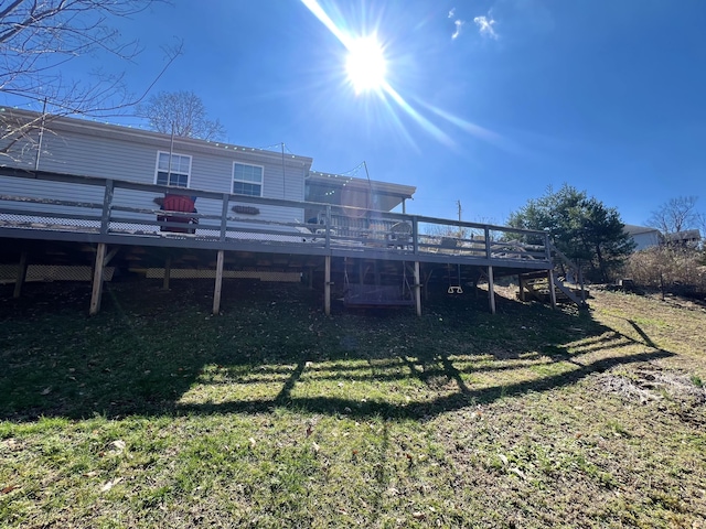 rear view of property featuring a lawn and a wooden deck