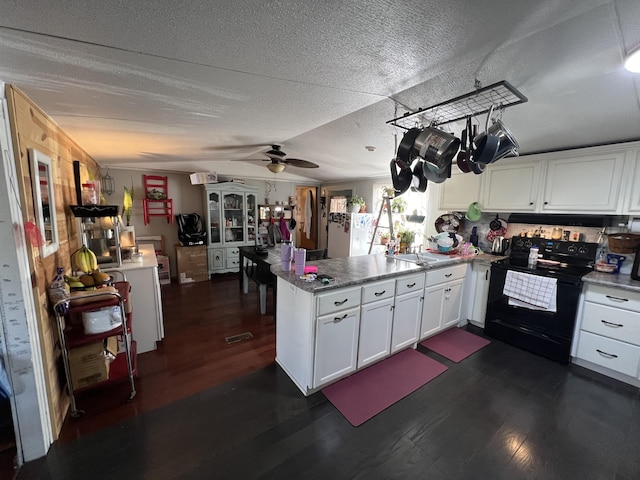 kitchen featuring a peninsula, black range with electric stovetop, dark wood-style flooring, white cabinets, and vaulted ceiling