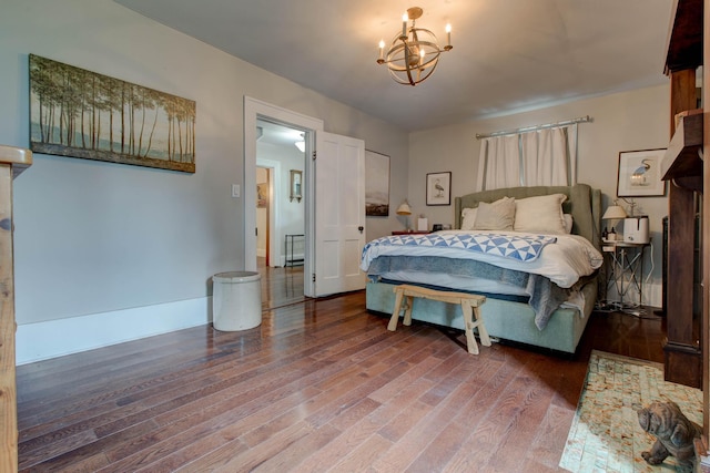 bedroom with baseboards, wood finished floors, and an inviting chandelier