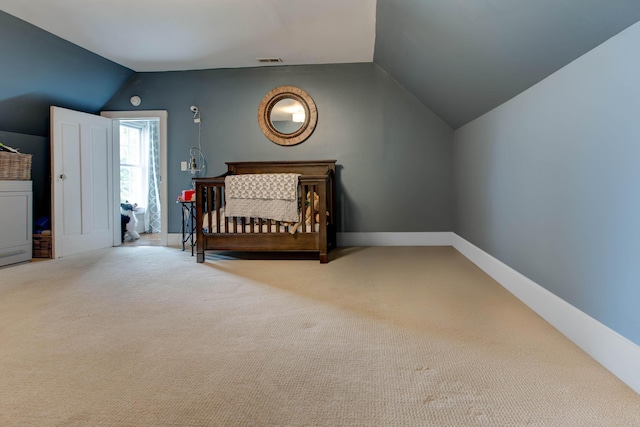 unfurnished bedroom featuring carpet, lofted ceiling, washer / clothes dryer, visible vents, and baseboards